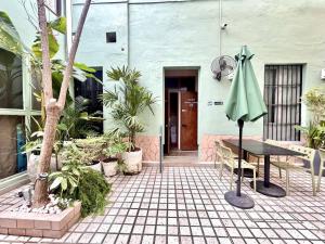 a patio with a table and a green umbrella at Habitacion Faro in Mazatlán