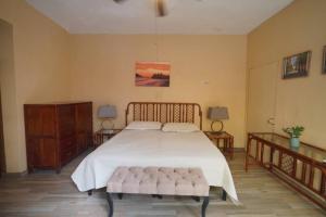 a bedroom with a large bed and two tables at Habitacion Machado in Mazatlán +6 photos