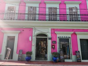 a pink and white building with a balcony at Habitacion Machado in Mazatlán