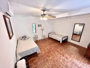 a bedroom with two beds and a ceiling fan at Habitacion Carnaval in Mazatlán