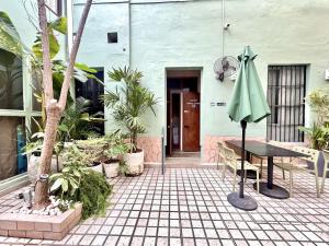 a patio with a table and a green umbrella at Habitacion Carnaval in Mazatlán
