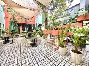 a courtyard with tables and potted plants in a building at Habitacion Carnaval in Mazatlán