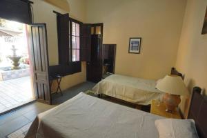 a bedroom with two beds and a lamp on a table at Casa Feliz Playa Norte in Mazatlán +3 photos