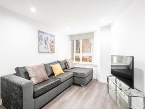 a living room with a couch and a flat screen tv at Casa Fresa - Castlehill Apartment in Dundee
