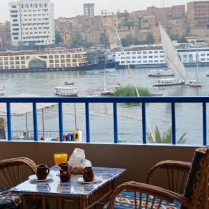 a table with a view of a river and a boat at Masa Nubian House in Aswan