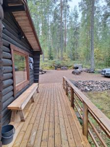 a wooden porch of a log cabin with a bench at Beautiful Cottage at Lake Saimaa, Rantamaja in Juva +17 photos