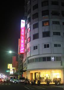 un edificio con un cartel en su costado por la noche en River Hotel, en Chiayi