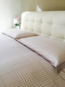 - un lit blanc avec 2 oreillers dans l'établissement CHARLOTTE casa vacanze, à Villa di Chiavenna