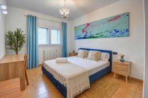 a bedroom with a bed and a table and a painting at Villa Ca Paulina in San Antonio +51 photos