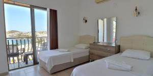 a hotel room with two beds and a balcony at Hotel Gumbet in Bodrum City +44 photos