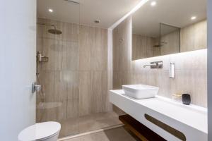 a bathroom with a sink and a toilet and a shower at Volaka Luxury Suites in Kos