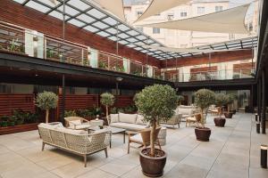 a lobby with couches and tables and potted trees at Hospes Palau de La Mar, Valencia, a Member of Design Hotels in Valencia