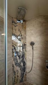 a bathroom with a shower with a stone wall at Ferienwohnung Haus Bader in Garmisch-Partenkirchen +10 photos