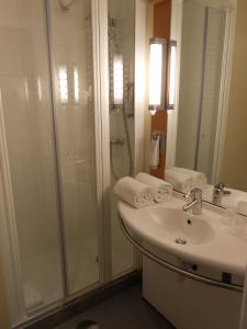a bathroom with a shower and a sink and a toilet at ibis Porto Centro São Bento in Porto