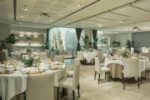 a banquet room with white tables and chairs at Hospes Palau de La Mar, Valencia, a Member of Design Hotels in Valencia