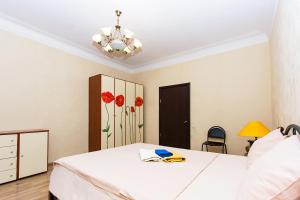 1 dormitorio con cama blanca y lámpara de araña en ApartLux Serpukhovskaya, en Moscú