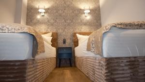two beds in a hotel room with two bedsskirts at Parkhotel Flora in Bad Grund +49 photos