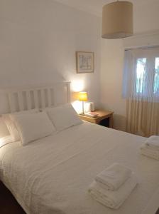 a bedroom with a white bed with two towels on it at Monte das Andorinhas Alentejo in Montemor-o-Novo