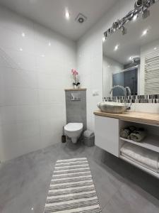 a bathroom with a toilet and a sink and a mirror at Modern in Suwałki +31 photos