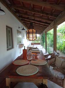 a wooden table in a living room with a chandelier at Monte das Andorinhas Alentejo in Montemor-o-Novo