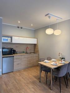 a kitchen and dining room with a table and chairs at Modern in Suwałki
