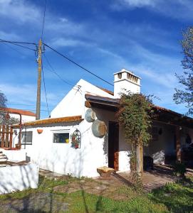 a white house with a tower on top of it at Monte das Andorinhas Alentejo in Montemor-o-Novo