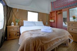 a bedroom with a large bed with towels on it at Cuckoo - Sweffling Hall in Rendham
