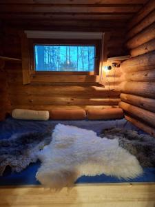 a room with a bed with a window and a rug at Beautiful Cottage at Lake Saimaa, Rantamaja in Juva