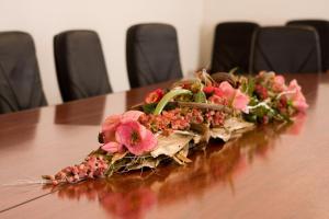 a wooden table topped with a bouquet of flowers at Hotel Complex Zelenyi Gai in Kopachuvka