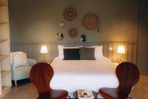 a bedroom with a large bed and two chairs at Domaine Etxezahar in Bardos