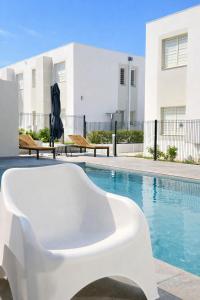 a white chair sitting next to a swimming pool at ONLY4VIEW Saint françois in Saint-François