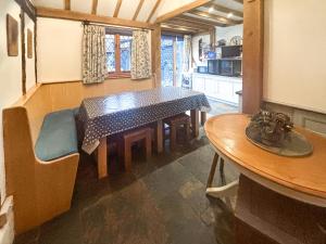 a dining room with a table and a kitchen at Rumbolds Retreat in Plaistow