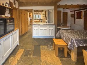 a kitchen and a living room with a bed and a table at Rumbolds Retreat in Plaistow