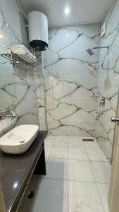 a bathroom with a sink and a marble wall at Hotel Ivory Hills in Kotdwāra +22 photos