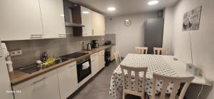 a kitchen with a table and a kitchen with white cabinets at Ilo's Zimmervermietung in Stadtallendorf