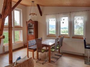 a dining room with a table and chairs and windows at Ferienwohnung Ruf in Küps