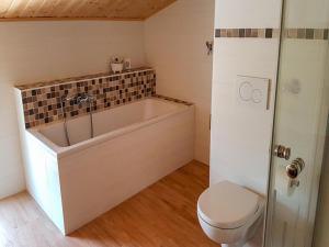 a bathroom with a tub and a toilet at Ferienwohnung Ruf in Küps
