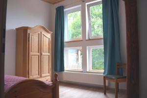 a bedroom with two windows and a bed and a chair at Ferienwohnung Ruf in Küps