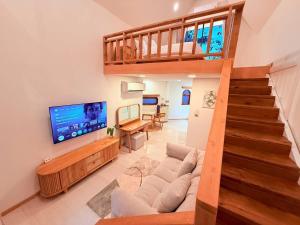a living room with a couch and a television at Lanta Forest Resort & Villas in Ko Lanta Yai