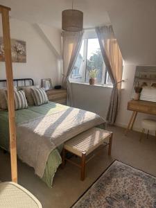a bedroom with a bed and a window and a desk at Grayrigge Croft Cottage in Grange Over Sands