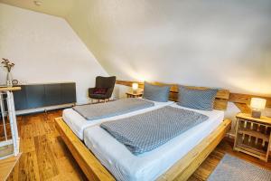 a bedroom with a large bed and a chair at Ferienwohnungen Etzl in Bad Mergentheim