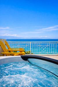 a swimming pool with a view of the ocean at Derveni Seaside Apartments - Deluxe Sea View Penthouse Jacuzzi-BBQ & Groundfloor Garden View Apartment in Derveni