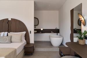 a bedroom with a large bed and a bath tub at Armony Suites Milos in Paliochori +102 photos