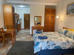 a bedroom with a bed and a table and a kitchen at Crayfish Inn no6 in Ramsgate