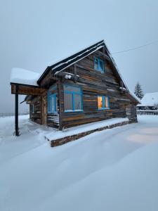 a log cabin in the snow at Casuta din Balcesti in Bălceşti +26 photos