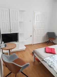 a room with a bed and a table and a chair at Erdős Panzió in Ditrău