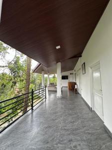 a large room with a wooden ceiling and a porch at Aththanayaka walawwa in Polgolla