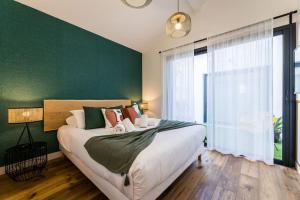 a bedroom with a large bed with a green wall at BLOOMY - Villa Biarritz in Biarritz