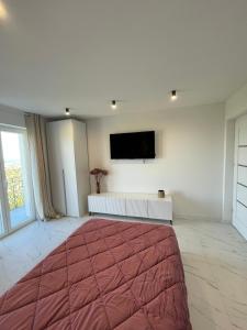 a bedroom with a large bed and a flat screen tv at Nela in Carini
