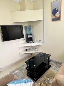 a living room with a tv and a table at Peaceful Place 1 in Nairobi